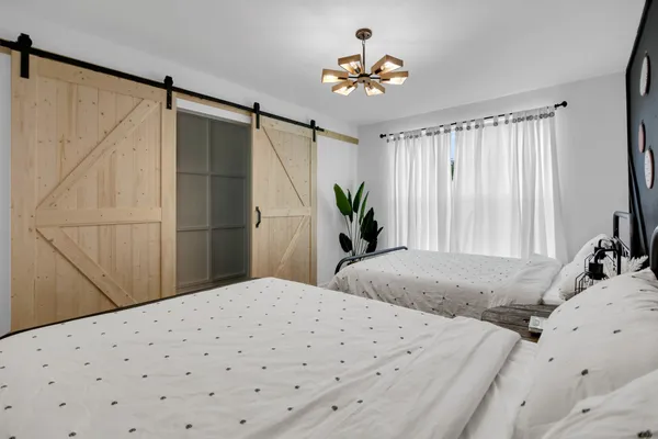 a bedroom with a large bed and a chandelier