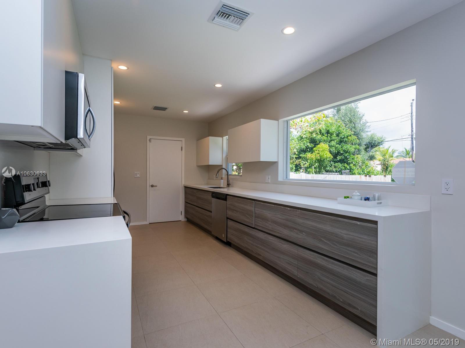 Contemporary custom made kitchen. White quartz counter-top. Stainless steel appliances.