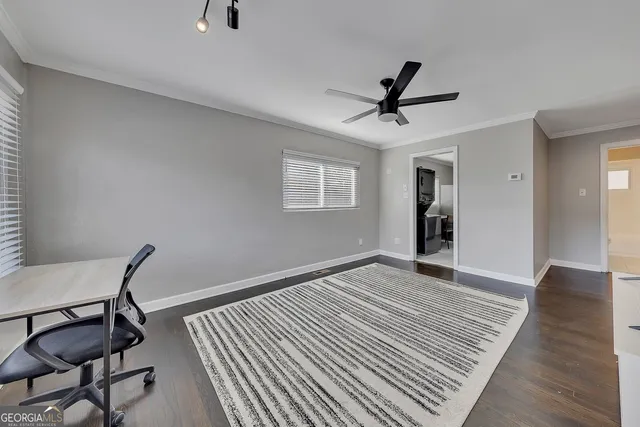a view of a livingroom with wooden floor and a ceiling fan