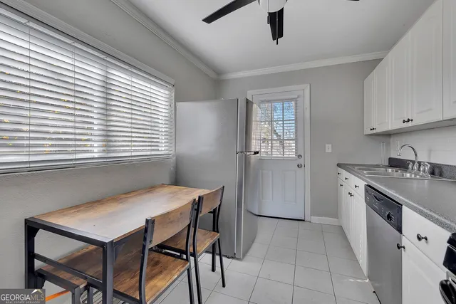 a kitchen with a table chairs refrigerator and cabinets