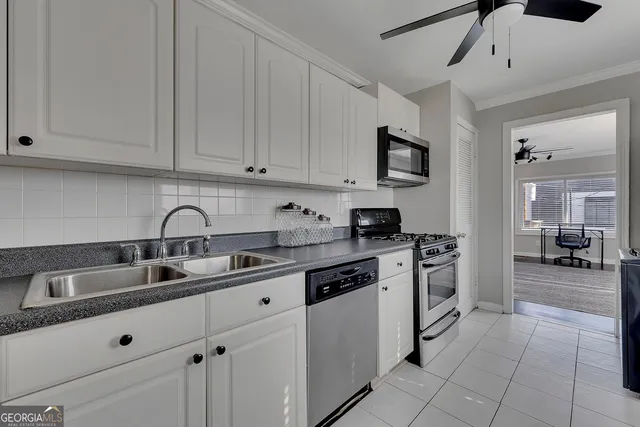 a kitchen with granite countertop a sink stainless steel appliances and cabinets