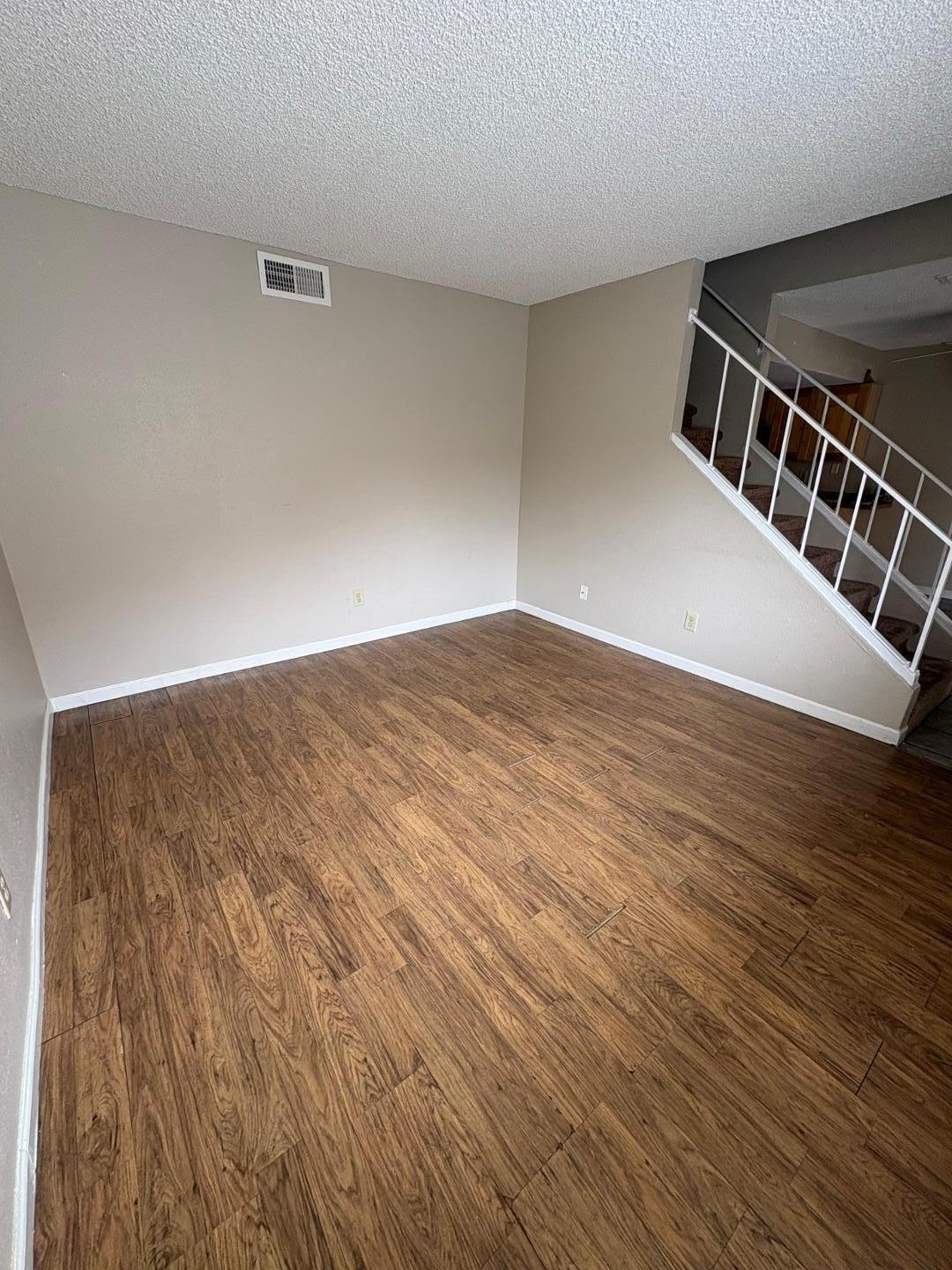 3511 East Baseline Road, Unit 1041 Phoenix, AZ 85042 - Photo 3 of 5 a view of an empty room with wooden floor and a window
