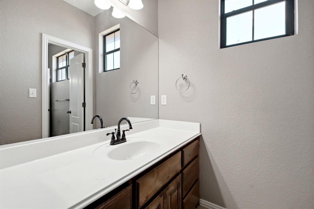 600 Aspen Street Pilot Point, TX 76258 - Photo 25 of 39 Bathroom vanity featuring a single basin, a dark bronze faucet, and a large mirror