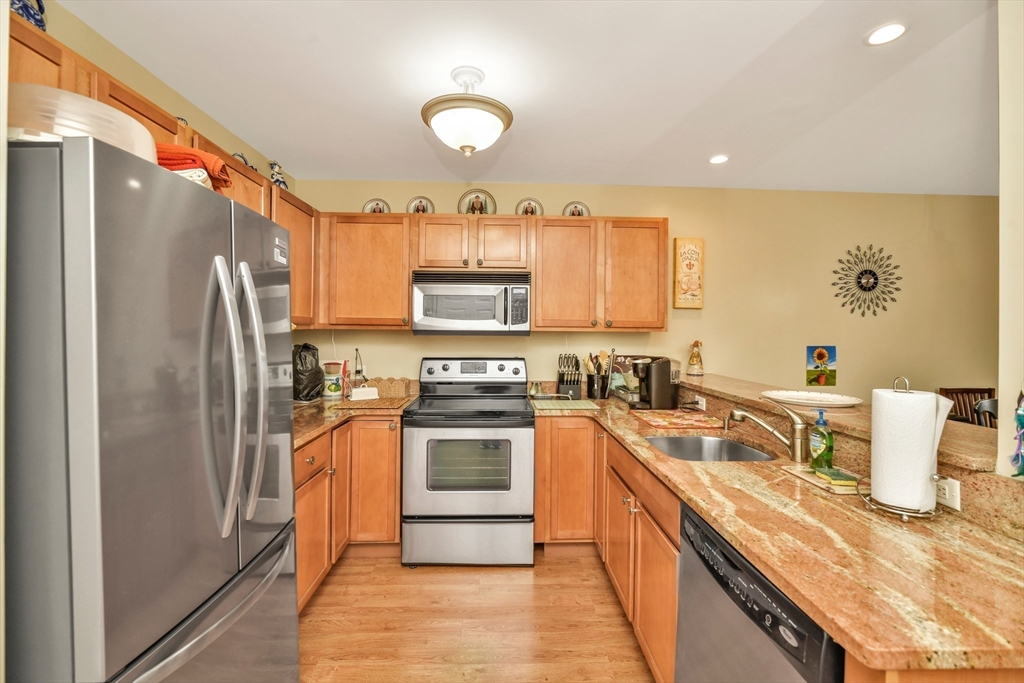 75 Walnut Street, Unit 315 Peabody, MA 01960 - Photo 3 of 14 a kitchen with stainless steel appliances granite countertop a sink stove and refrigerator