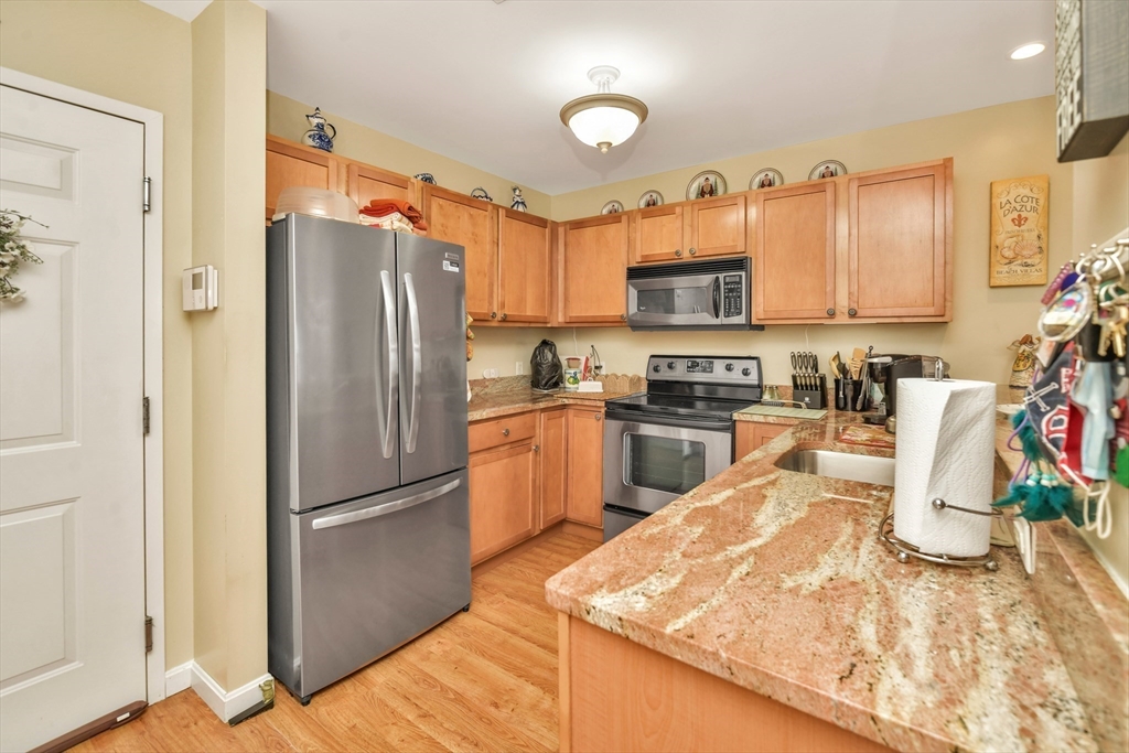 75 Walnut Street, Unit 315 Peabody, MA 01960 - Photo 4 of 14 a kitchen with granite countertop a refrigerator stove top oven and sink
