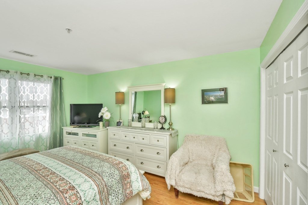 75 Walnut Street, Unit 315 Peabody, MA 01960 - Photo 10 of 14 a bedroom with a bed and a flat tv screen on dresser