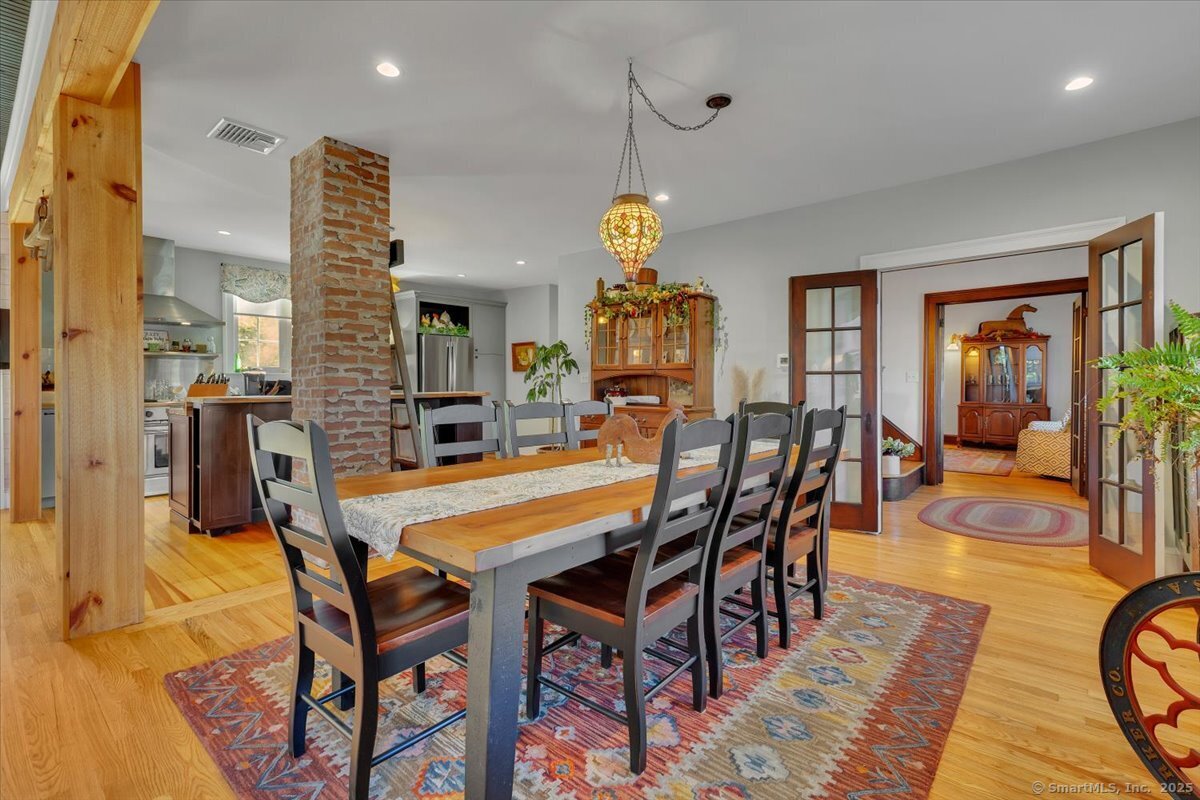 a dining room with furniture a chandelier and wooden floor