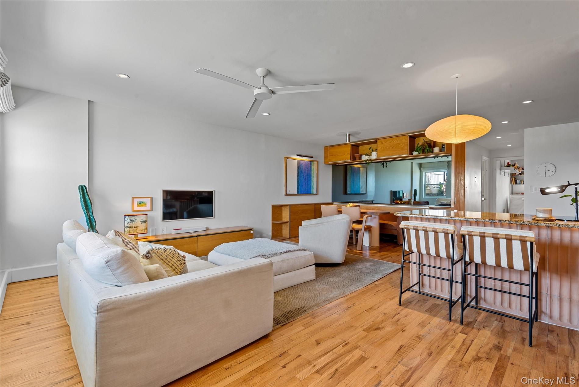 100-12 Shore Front Parkway, Unit 18A Queens, NY 11694 - Photo 11 of 37 a living room with furniture and a wooden floor