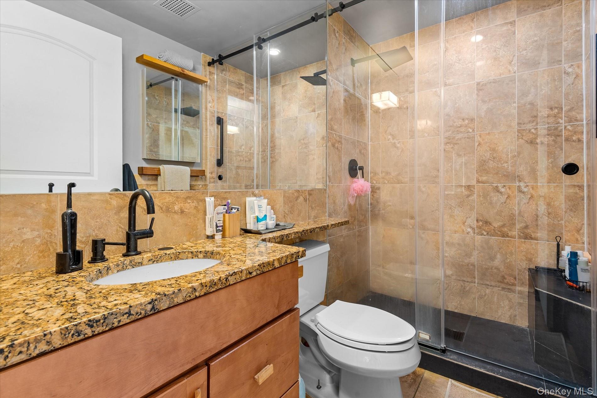 100-12 Shore Front Parkway, Unit 18A Queens, NY 11694 - Photo 20 of 37 a bathroom with a granite countertop sink toilet and shower