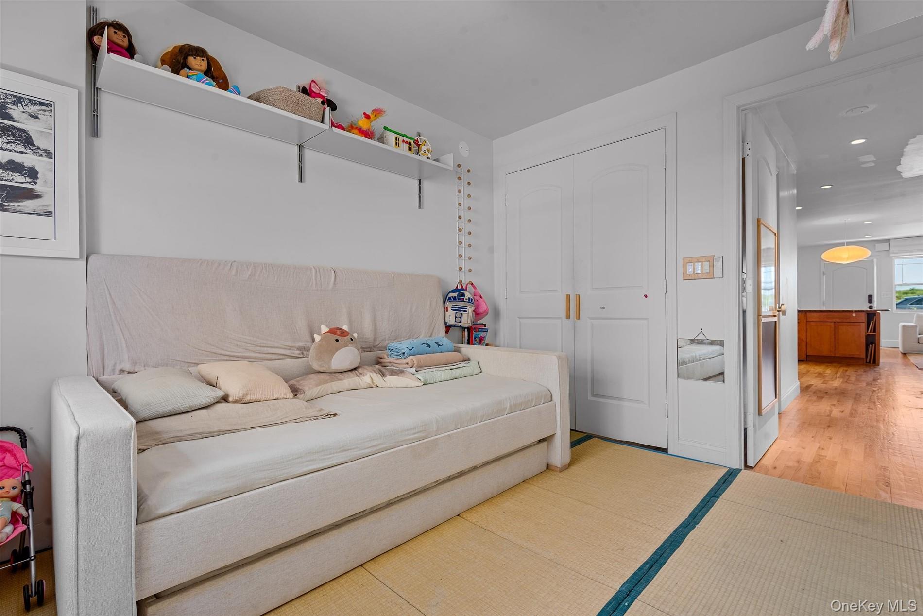 100-12 Shore Front Parkway, Unit 18A Queens, NY 11694 - Photo 22 of 37 a bed room with a bed and a couch