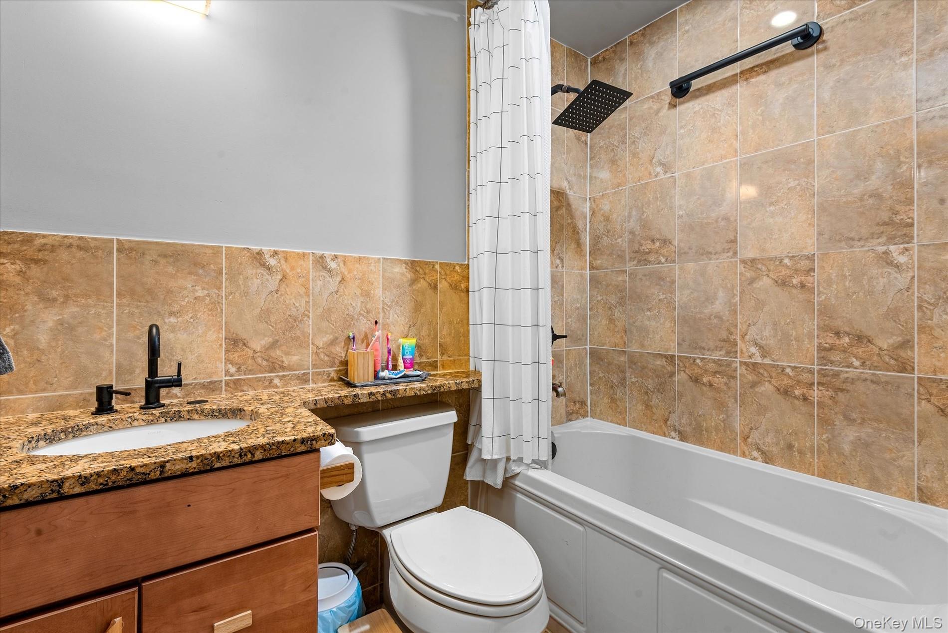 100-12 Shore Front Parkway, Unit 18A Queens, NY 11694 - Photo 23 of 37 a bathroom with a granite countertop bathtub sink vanity mirror and toilet