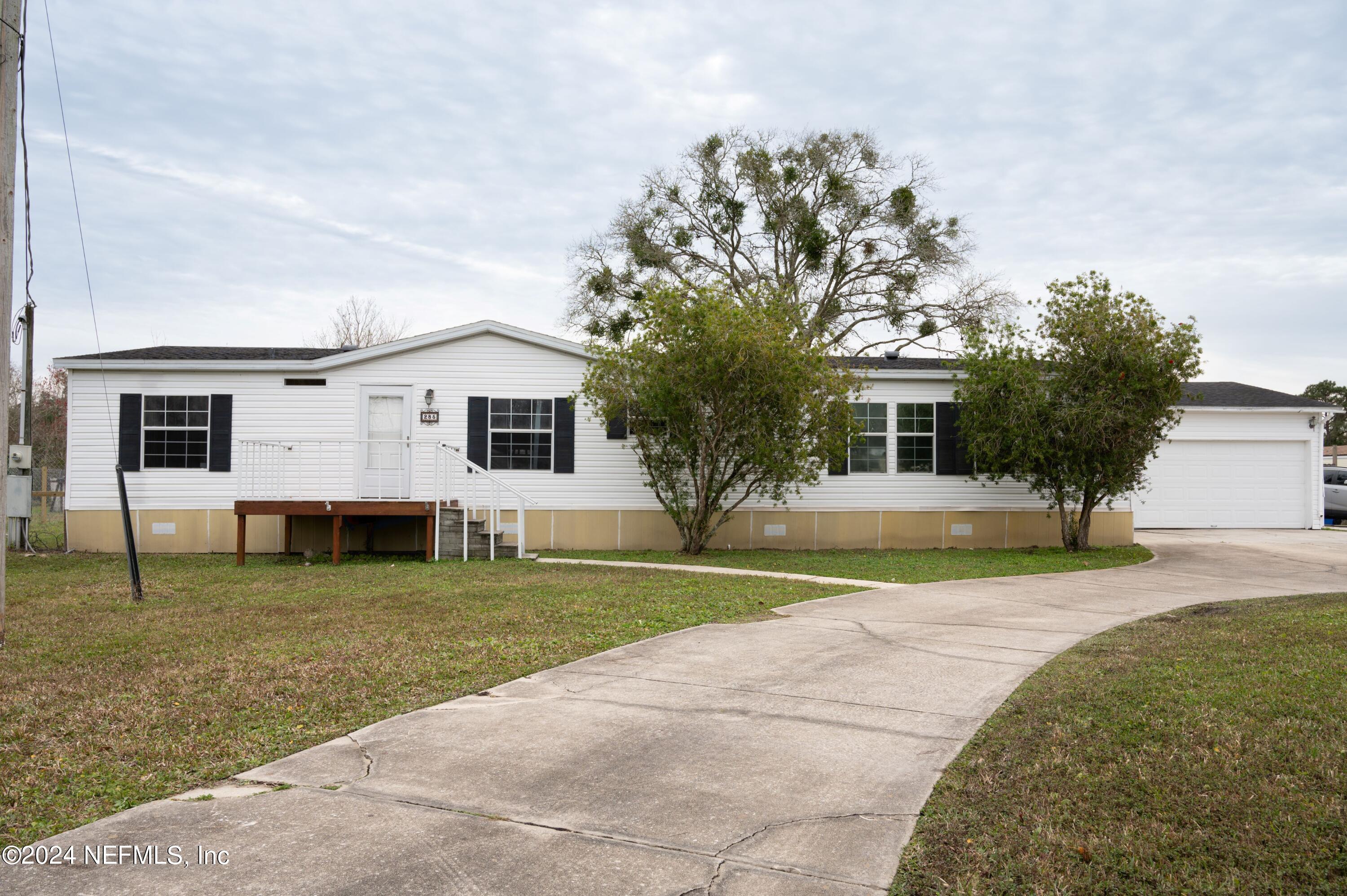 285 Dusty Road St. Augustine, FL 32095 - Photo 1 of 40 a view of a yard in front of a house with plants and large tree