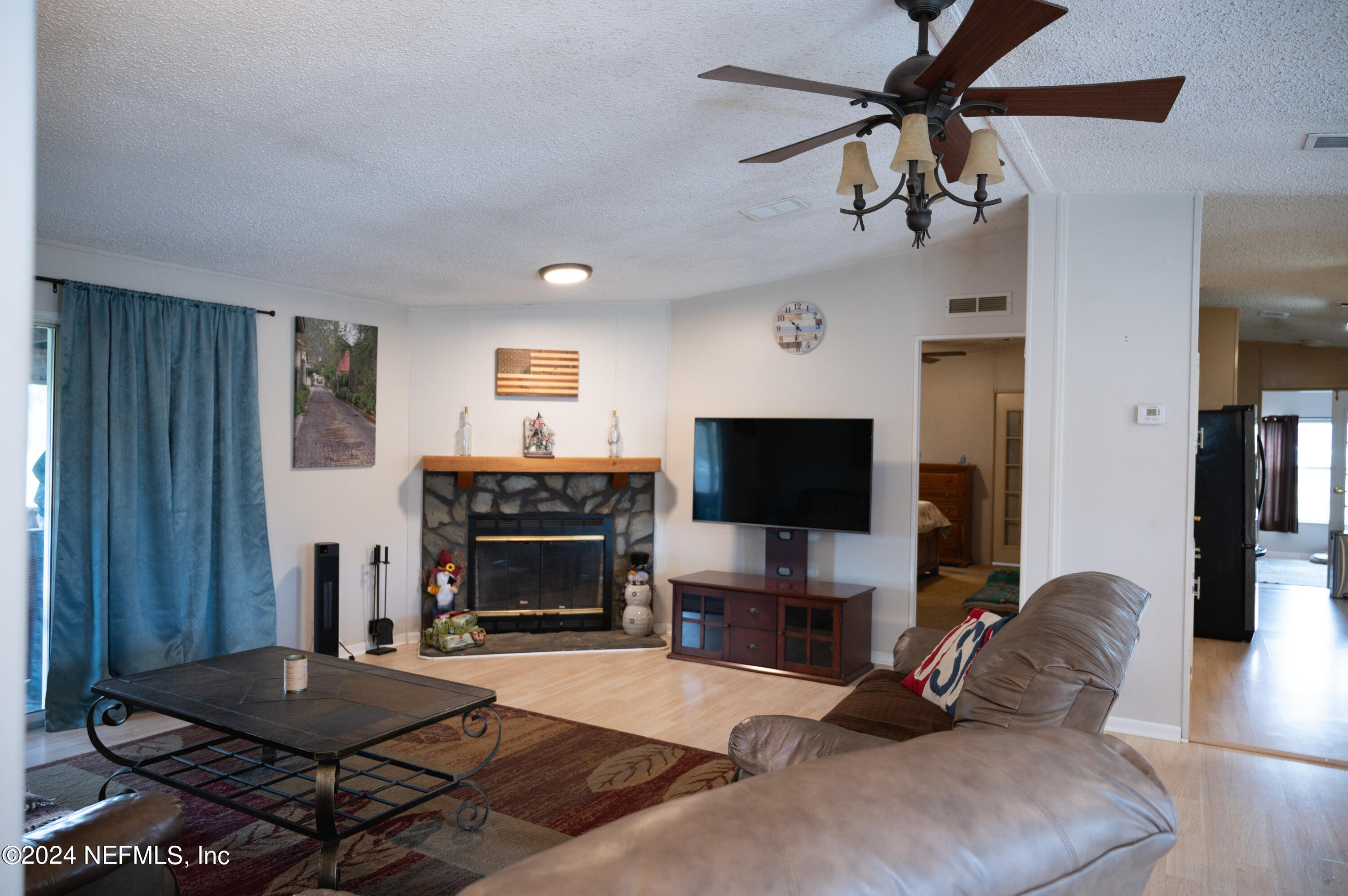 285 Dusty Road St. Augustine, FL 32095 - Photo 12 of 40 a living room with furniture a fireplace and a flat screen tv