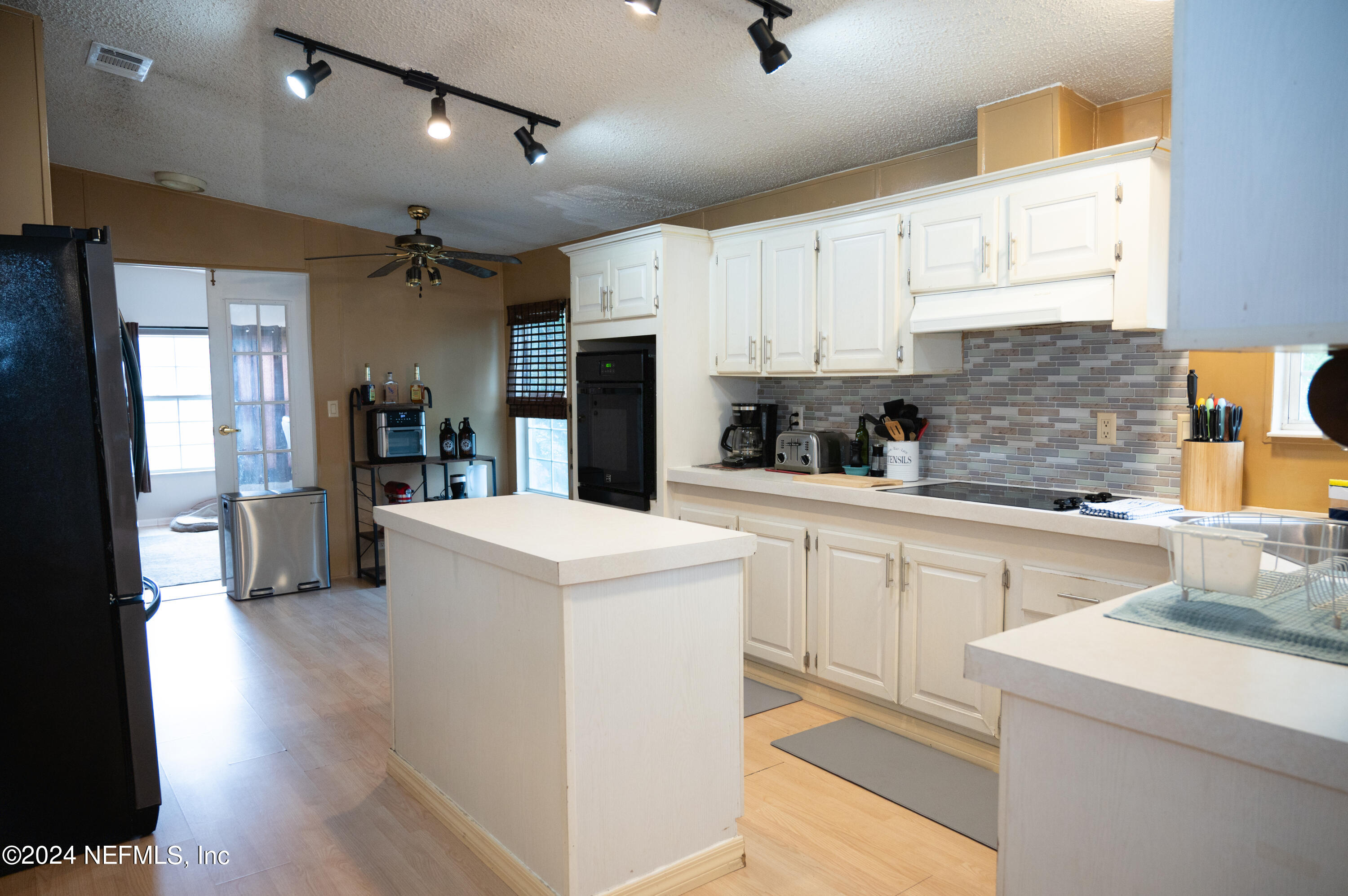 285 Dusty Road St. Augustine, FL 32095 - Photo 13 of 40 a kitchen with a sink a refrigerator and cabinets