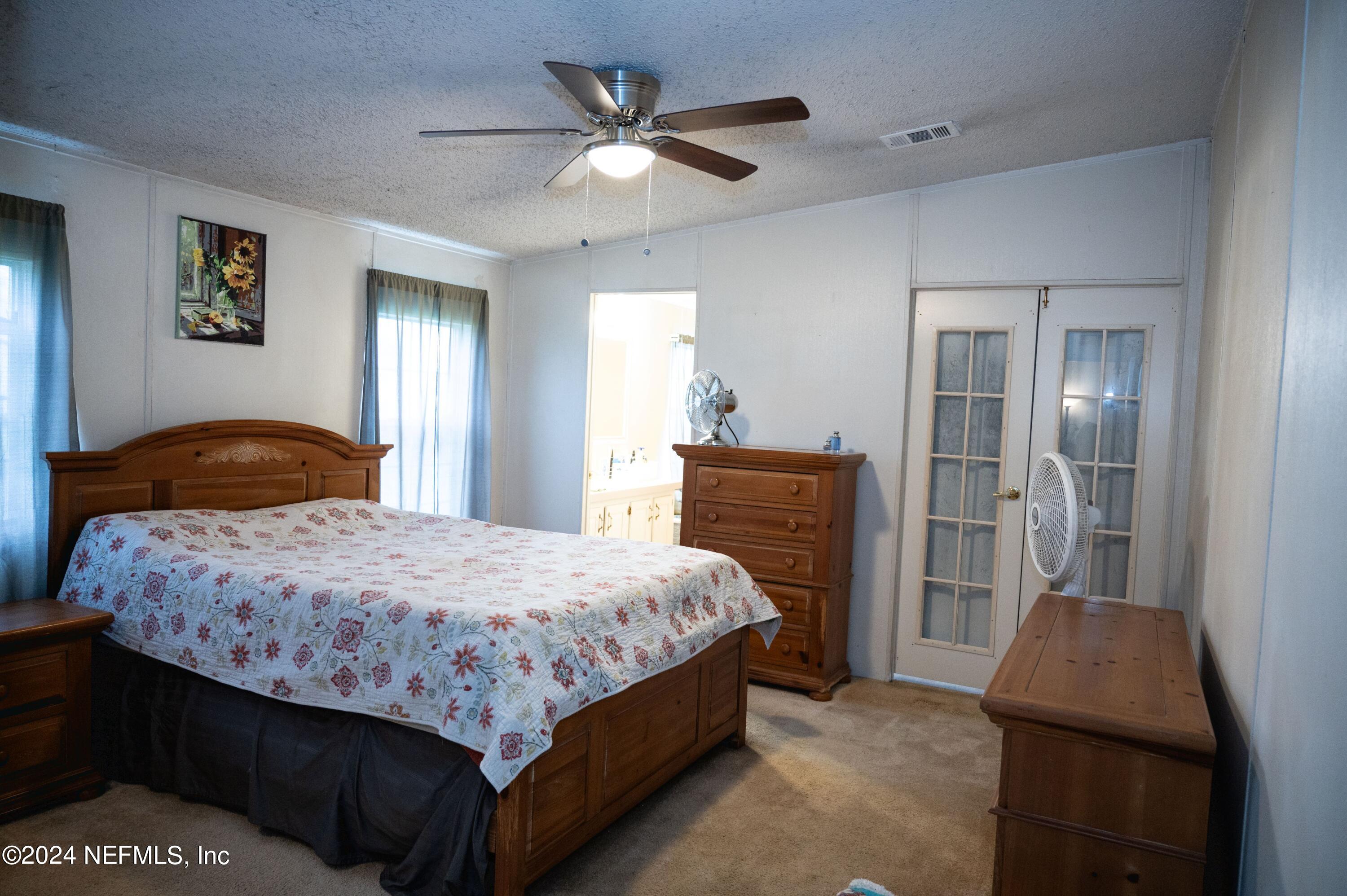 285 Dusty Road St. Augustine, FL 32095 - Photo 20 of 40 a bedroom with a bed and a chandelier