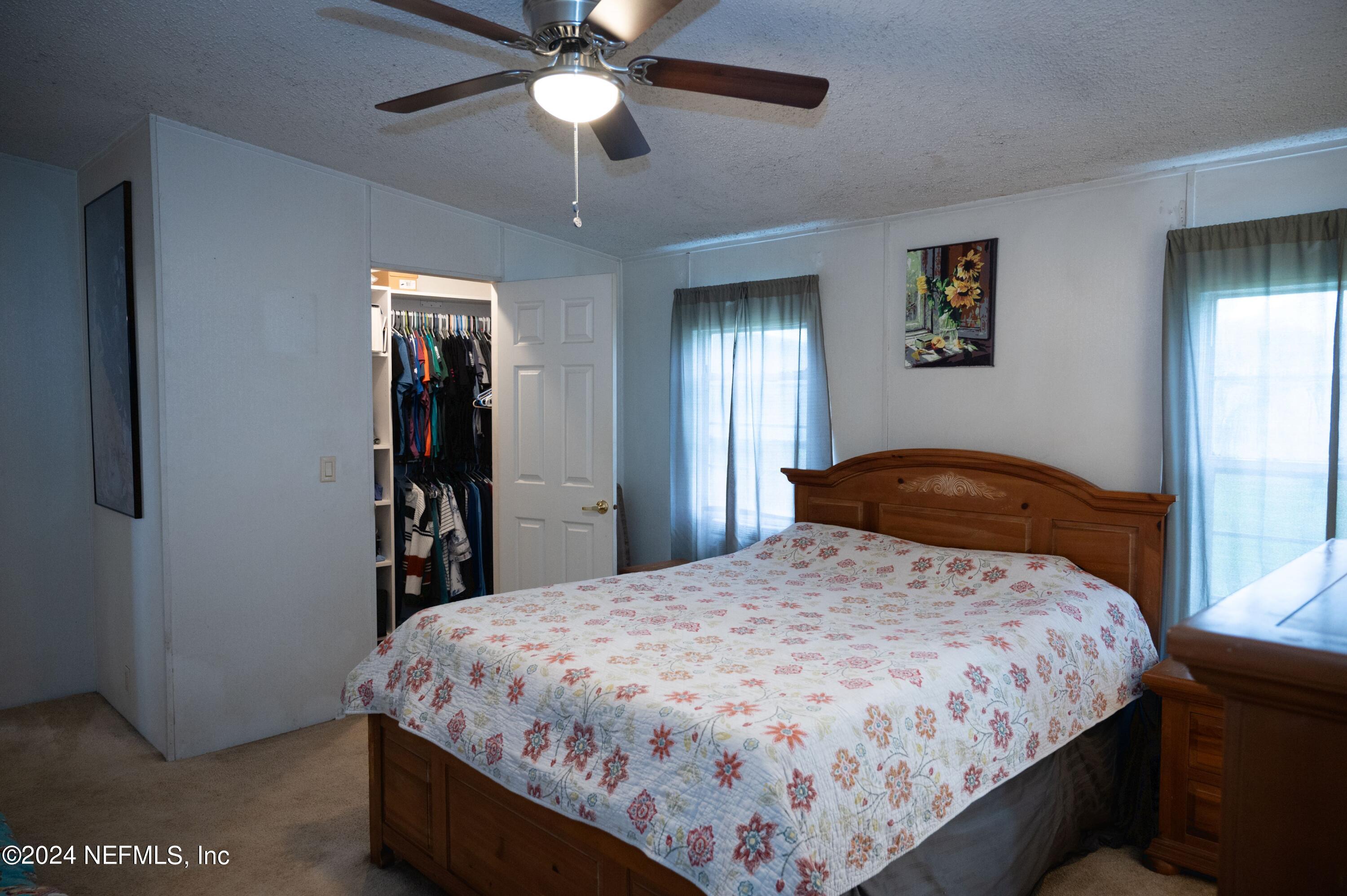 285 Dusty Road St. Augustine, FL 32095 - Photo 21 of 40 a bedroom with a bed and a chandelier