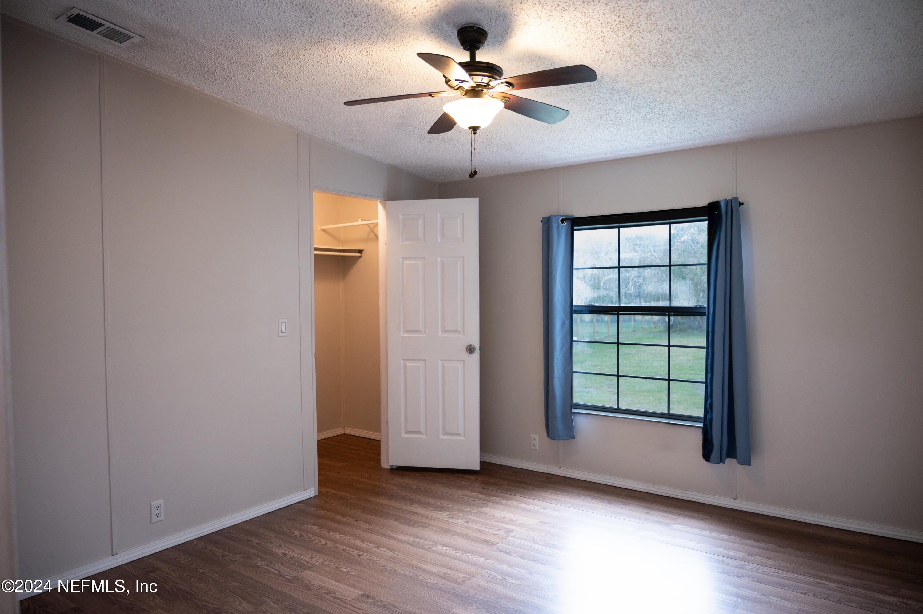 285 Dusty Road St. Augustine, FL 32095 - Photo 22 of 40 wooden floor in an empty room with a window