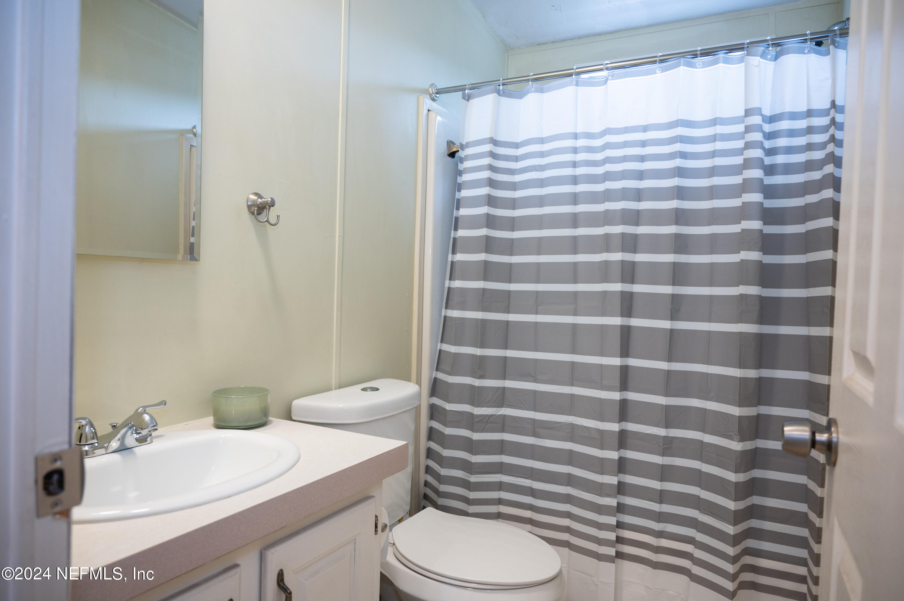 285 Dusty Road St. Augustine, FL 32095 - Photo 24 of 40 a bathroom with a sink a toilet a mirror and shower curtain
