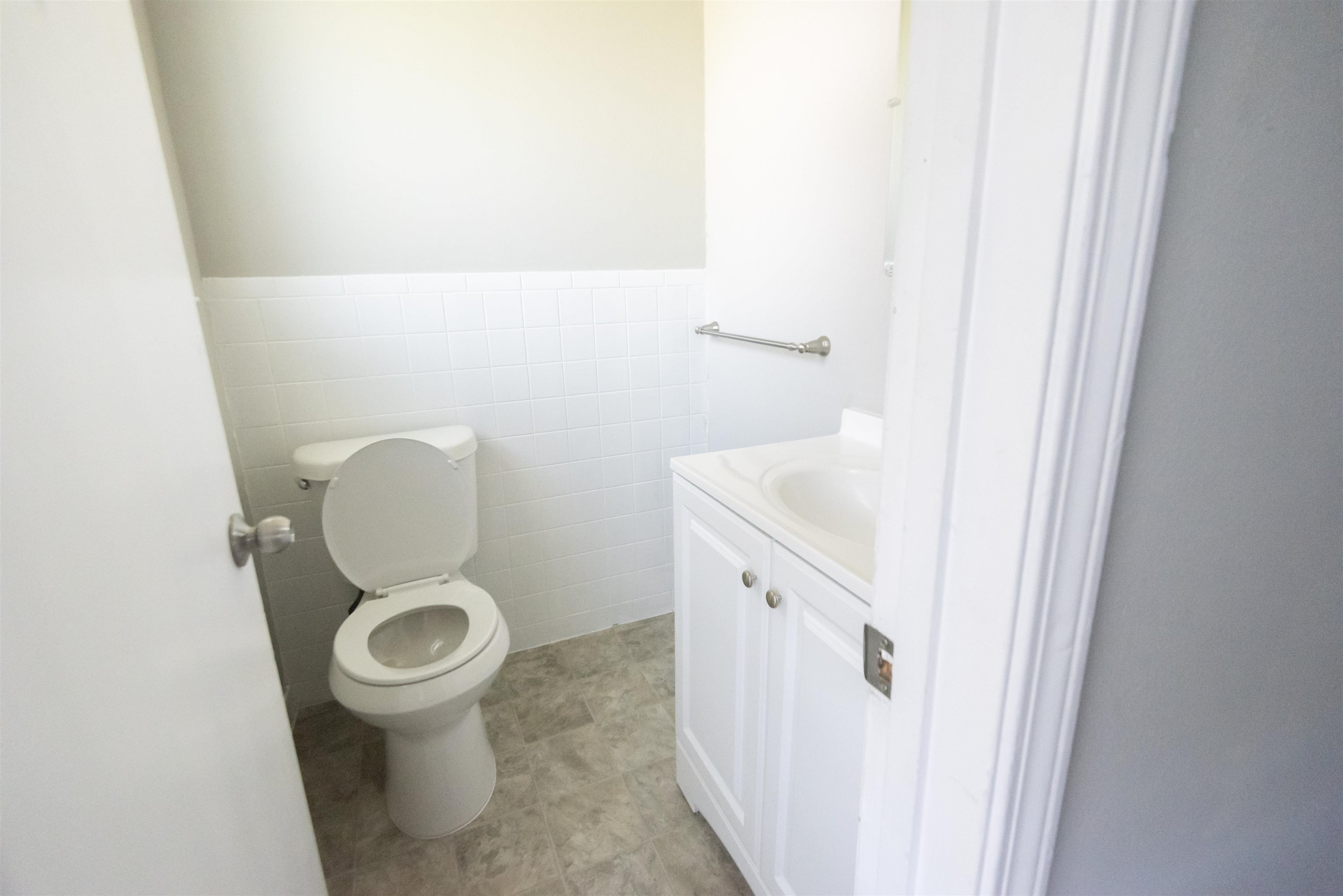 4399 Pepper Tree Road Memphis, TN 38109 - Photo 3 of 14 Half bathroom featuring vanity, tile walls, and a wainscoted wall