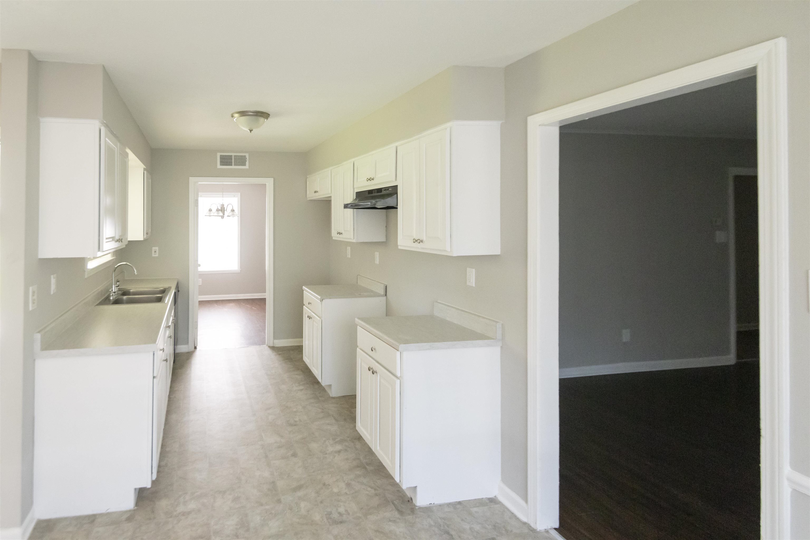 4399 Pepper Tree Road Memphis, TN 38109 - Photo 4 of 14 Kitchen with light countertops, white cabinets, and light flooring