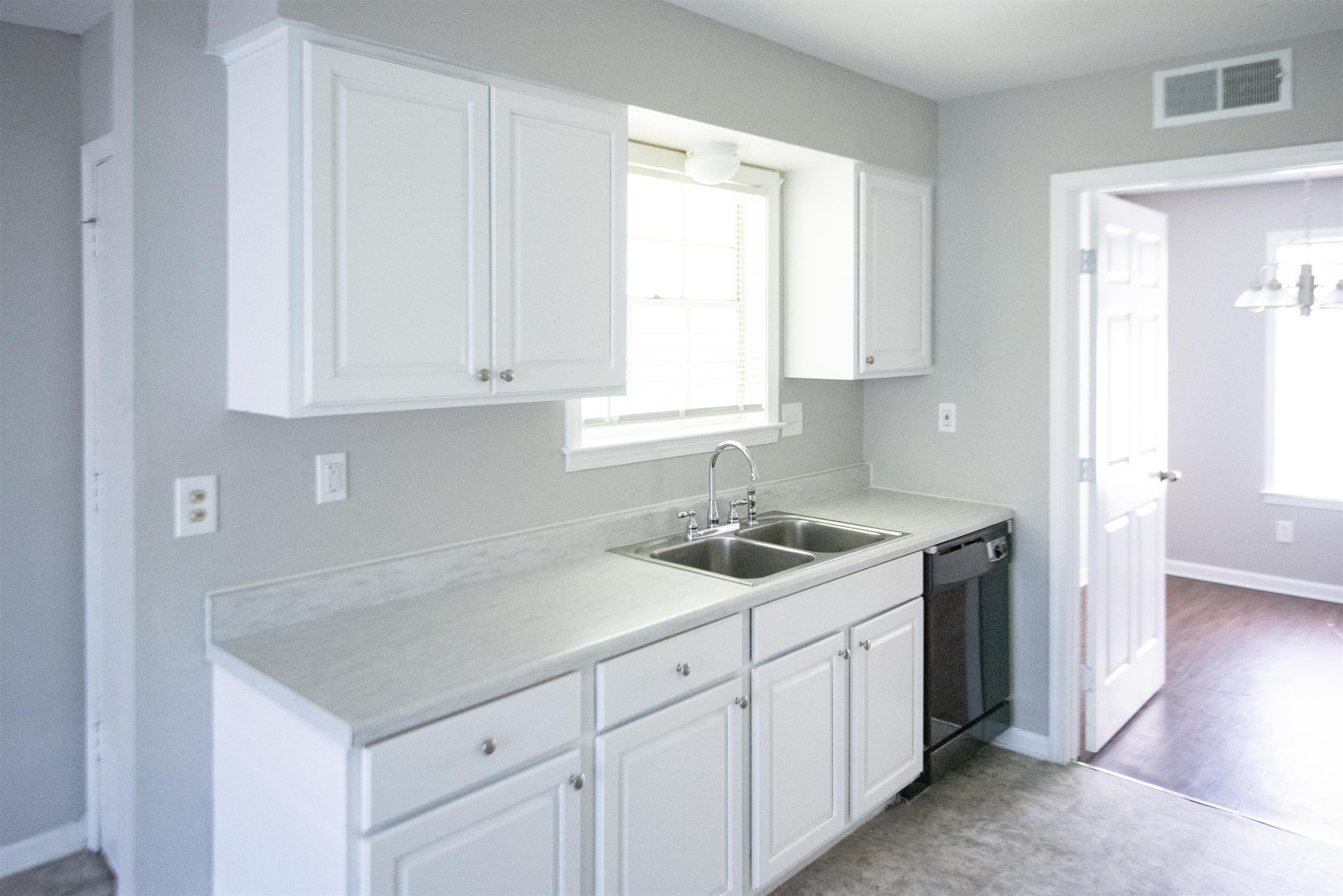 4399 Pepper Tree Road Memphis, TN 38109 - Photo 6 of 14 Kitchen with white cabinetry, light countertops, dishwasher, and hanging lights