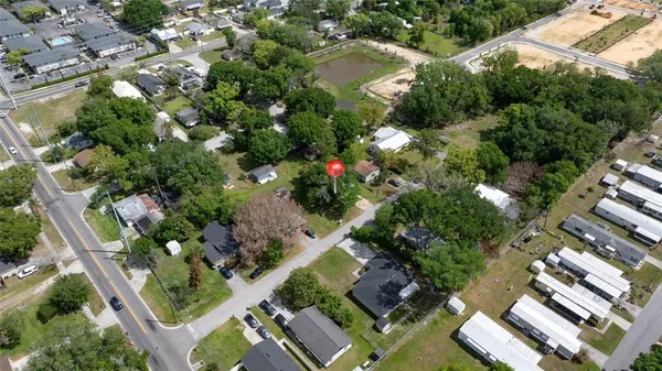 an aerial view of residential house with outdoor space and trees all around