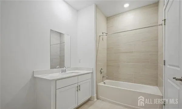 a bathroom with a bathtub sink vanity and a mirror