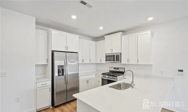 a kitchen with cabinets and stainless steel appliances