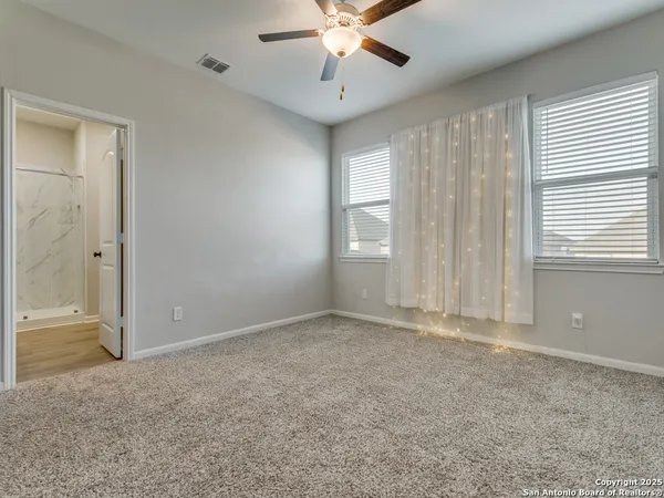 an empty room with fan and windows