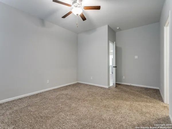 an empty room with chandelier fan