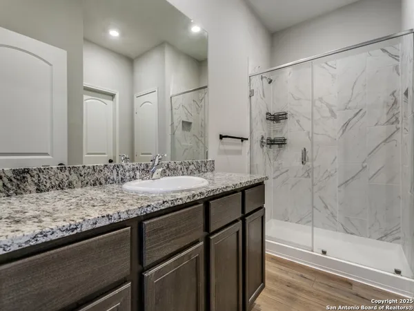 a bathroom with a granite countertop sink and a mirror