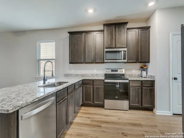a kitchen with stainless steel appliances granite countertop a sink stove and microwave