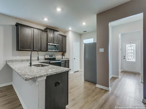 a kitchen with stainless steel appliances granite countertop wooden cabinets a refrigerator and microwave