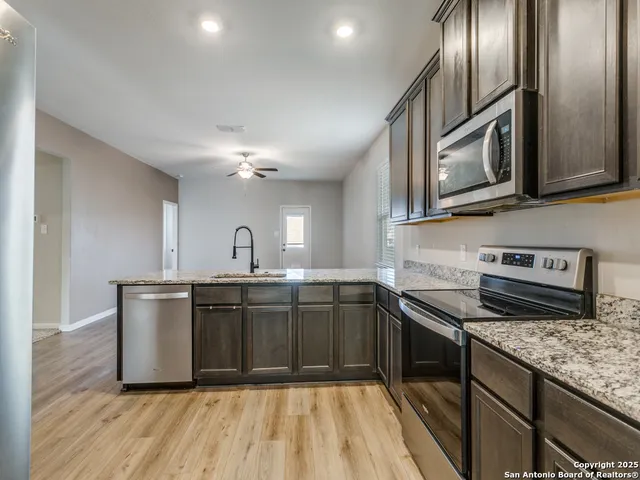 a kitchen with stainless steel appliances granite countertop a sink stove and refrigerator