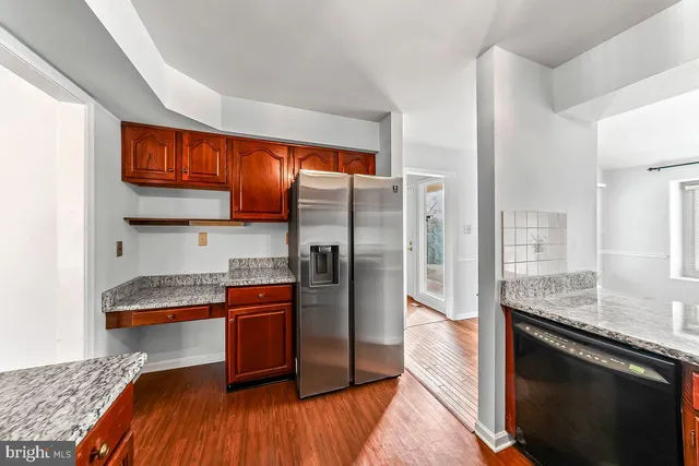 a kitchen with stainless steel appliances granite countertop a refrigerator a stove and a sink