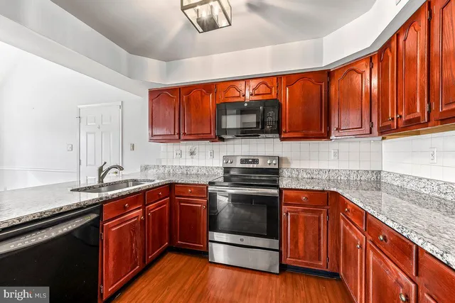 a kitchen with stainless steel appliances wooden cabinets and a stove top oven