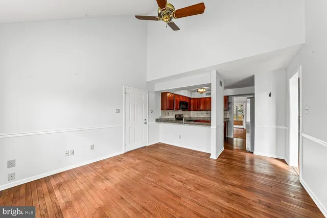 a view of a kitchen with wooden floor and a ceiling fan