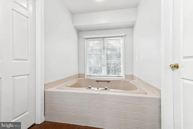 a bathroom with bathtub and window