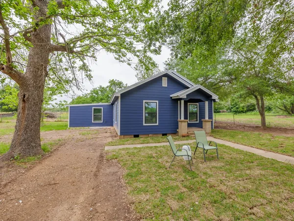 a view of a house with backyard and a tree