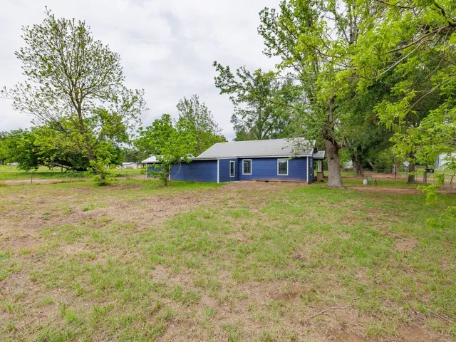a front view of a house with a yard and trees