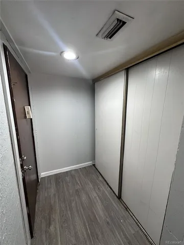 an empty room with wooden floor and entrance