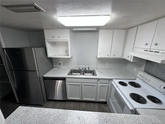 a kitchen with a sink a refrigerator and cabinets