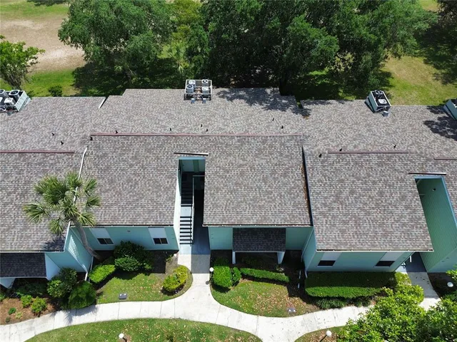 a aerial view of a house with a yard and large tree