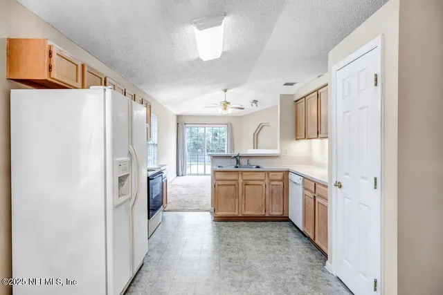 a view of a livingroom with a ceiling fan a fireplace and a chandelier fan