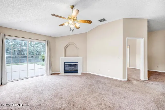 a view of an empty room with a chandelier fan
