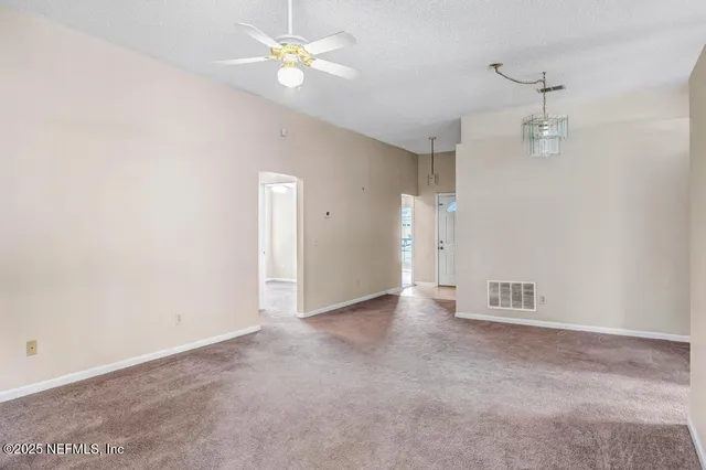an empty room with a window and a ceiling fan