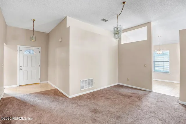 a view of a room with cabinet and a chandelier fan