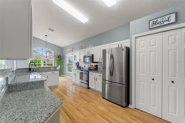 a kitchen with stainless steel appliances granite countertop a refrigerator stove and sink
