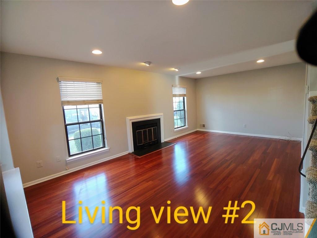 3305 Stonehedge Road Edison, NJ 08820 - Photo 4 of 14 a view of an empty room with window and wooden floor