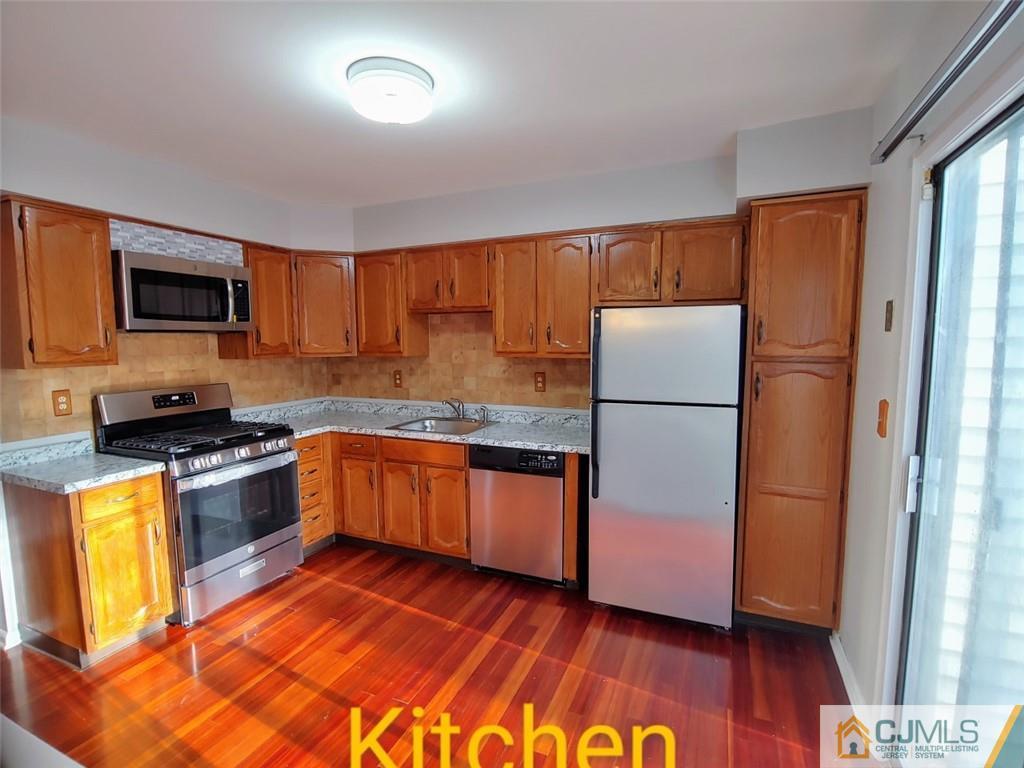 3305 Stonehedge Road Edison, NJ 08820 - Photo 7 of 14 a kitchen with granite countertop wooden floors a stove a sink and a refrigerator